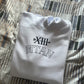 Folded white hoodie with black text on a patterned surface